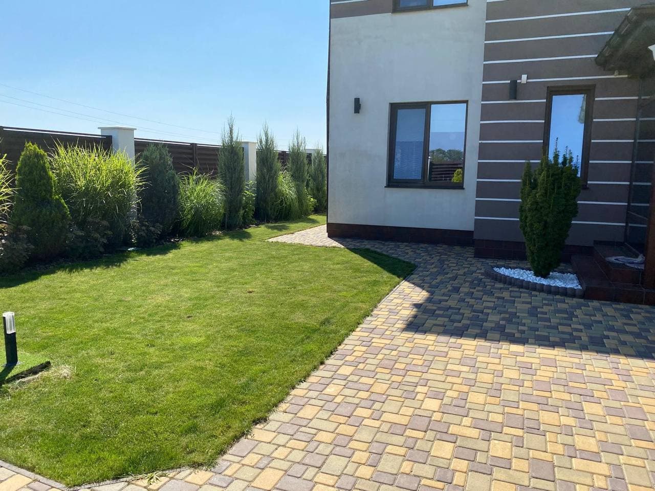 Modern garden with paved pathway and green lawn